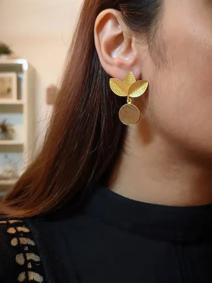 A side profile shot of me wearing the gold-plated floral stud with a dangling disc, a perfect example of minimal yet elegant design.
