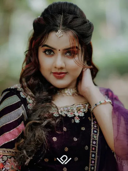 A close-up portrait highlighting the bride's beautiful makeup and hairstyle, with striking red streaks in her hair.