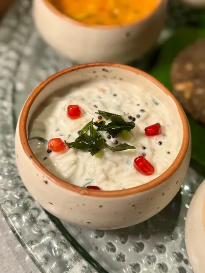 A cooling raita with pomegranate seeds, providing a perfect balance to the spicier dishes on the thali.
