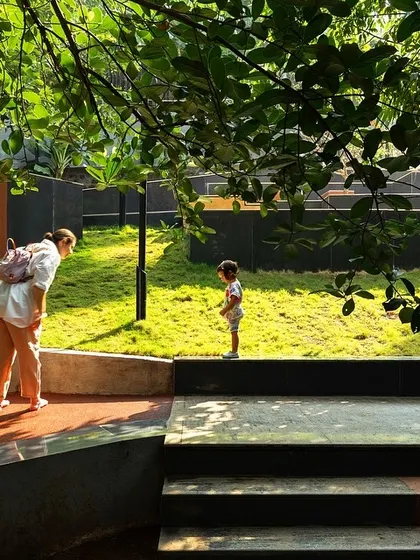 A child and adult explore the lush, sloping lawns at Nepean Greens. The design offers a variety of textures and levels, encouraging play and interaction with nature in the middle of the city.