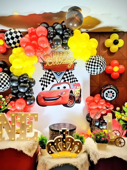 Another Cars themed party with a focus on red, yellow, and black balloons and a large 'ONE' sign.