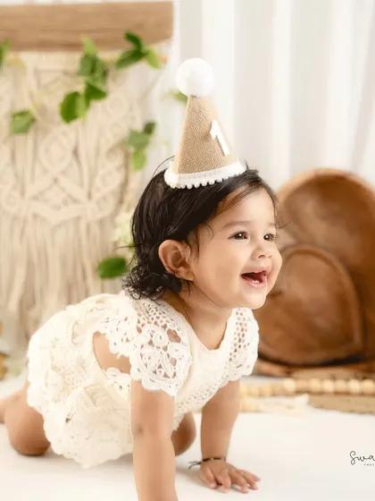 A candid crawling shot from a bohemian-inspired first birthday session. The natural textures and light colors create a warm, earthy feel.