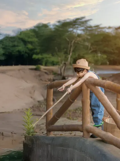 A moment of quiet concentration. Even the pretend act of fishing on a rustic bridge makes for a beautiful and story-driven photograph.