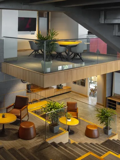 This high-angle shot of the Primarc office highlights the various zones for work and relaxation. The design integrates meeting pods, lounge areas, and informal seating, giving employees the flexibility to choose how and where they work.