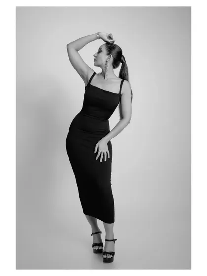 A classic and elegant black and white fashion portrait. The simple dress and graceful pose create a timeless and sophisticated image.