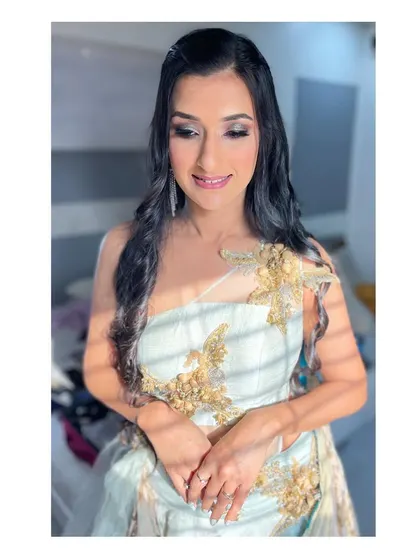 Sun-kissed and glowing. This sangeet look features warm, shimmery eyeshadow and luminous skin, paired with long, flowing curls for a touch of romance.