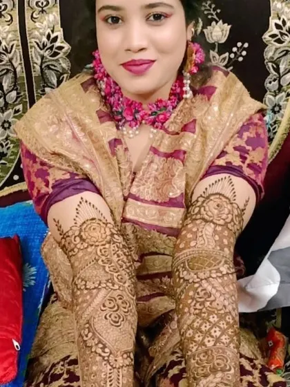 This bride looks absolutely radiant, ready for her mehndi ceremony. Her arms are covered in a detailed floral and geometric pattern.