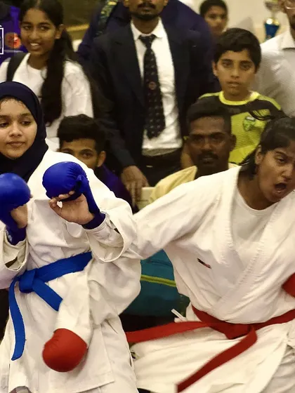 The fire of competition. Two female fighters from opposing teams clash during a tournament, showcasing the power and spirit of women in sports karate.