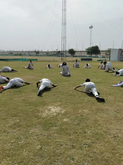 Cool-downs and flexibility are just as important as the main workout. Here, players are performing essential stretches to aid muscle recovery and improve their range of motion for better performance.