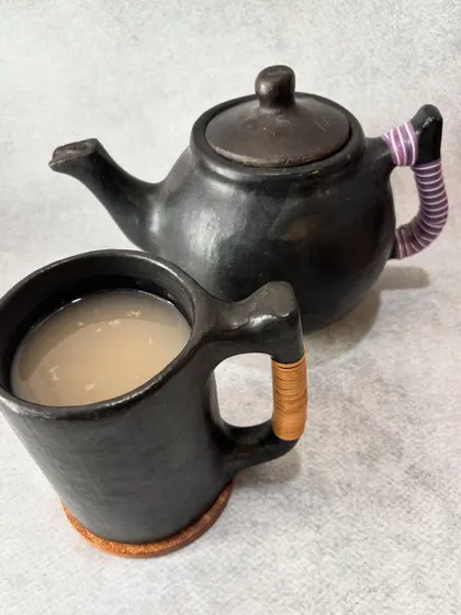 We serve our traditional fermented rice drink, a light and tangy beverage, in handcrafted Longpi pottery. This black pottery is made by artisans in Manipur from a special blend of stone and clay, bringing a piece of our heritage to your table.