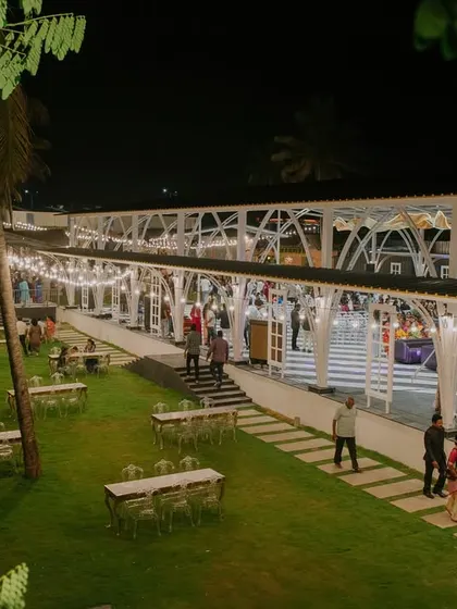 An expansive outdoor reception venue, beautifully lit for an evening of celebration. The combination of open lawn space for mingling and a covered, well-lit structure for dining and dancing shows our expertise in full-venue design.