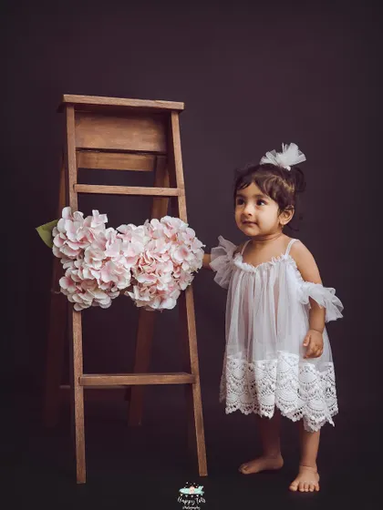 So simple, yet so sweet. A little girl in a white dress against a dark background creates a striking and elegant portrait.