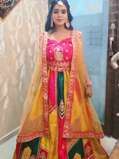 This happy client chose a vibrant multi-colored lehenga for her event, looking absolutely stunning and full of life.