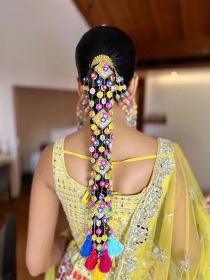 The final look from the back. The colorful accessories on the braid tie in perfectly with her mirror-work lehenga.