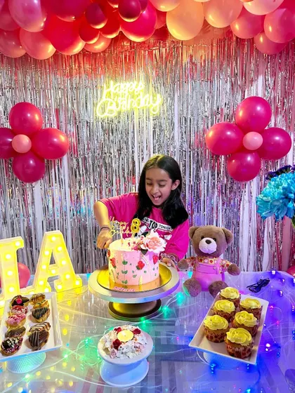 The birthday girl enjoying her floral cake. Seeing the joy my cakes bring to celebrations is the best part of my job.