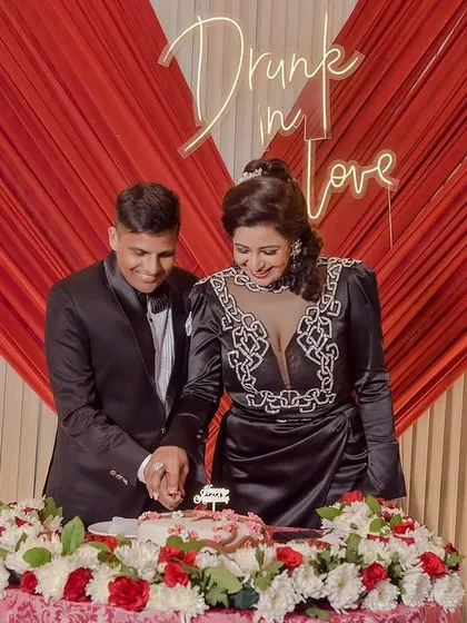 The couple cutting their reception cake together, a sweet moment in their celebration.