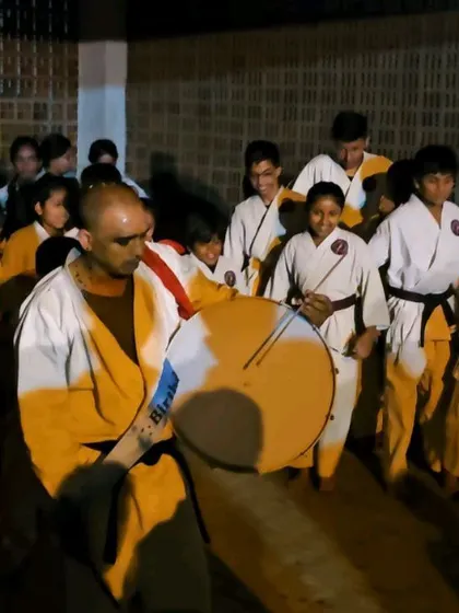 Leading the procession with a drum. Our celebrations are a vibrant part of our academy's culture.