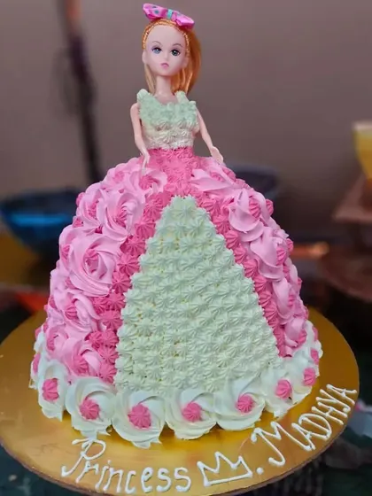 A classic Barbie doll cake, where the doll's gown is created with beautiful pink and green buttercream piping. A timeless choice for a princess-themed party.