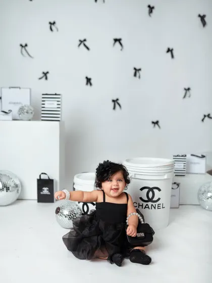 A big, joyful smile from the baby of the family, showing that even high-fashion shoots can be full of fun and giggles.