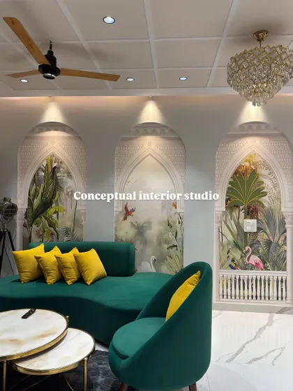 This living room in a 4BHK features stunning arched wall panels with tropical wallpaper, creating a grand and artistic focal point. The emerald green sofa adds a touch of luxury.
