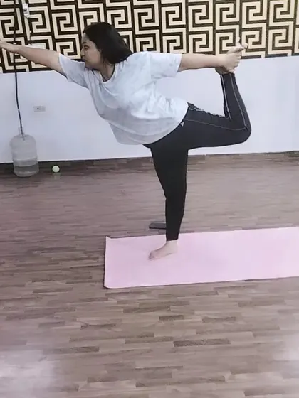 A graceful execution of Natarajasana, the dancer's pose. This posture challenges your balance while providing a deep stretch for the shoulders and chest.