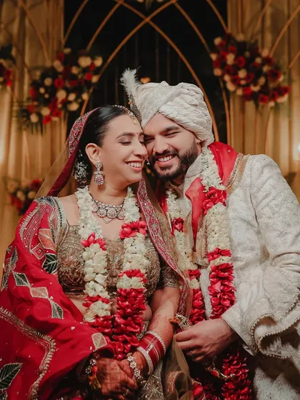 A beautiful, candid moment of the couple sharing a laugh after their Jaimala ceremony. This shot perfectly captures the happiness and relief of being married, surrounded by the warmth of the decor.