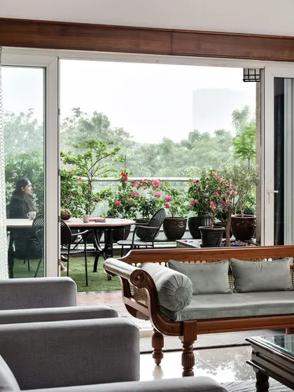 A view from the living room out to the lush terrace garden. We designed the space to embrace the green canopies of Bengaluru, making it a true garden city apartment.