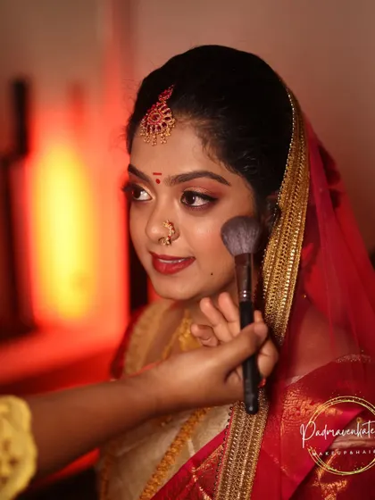 A candid moment of me applying blush to a bride for her muhurtham. This behind-the-scenes shot shows the final touches that bring the whole look together and add that perfect flush of color.