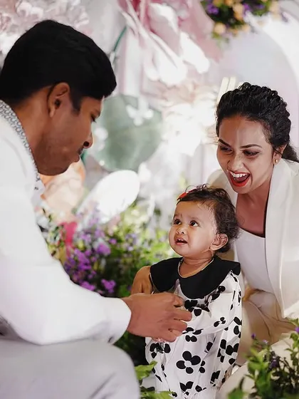 Capturing the wonder in a child's eyes is what it's all about. This candid moment between the birthday girl and her parents in front of the floral backdrop is a memory they'll cherish forever.