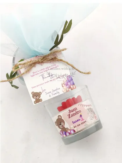A close-up of the packaged birthday return gift, showing the personalized tag and teddy bear theme.