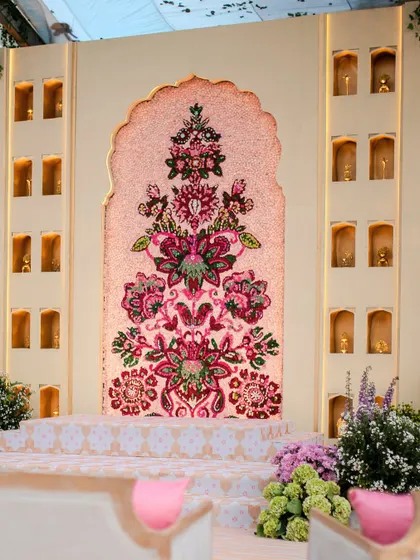 The Jaimala stage, featuring a stunning floral mosaic wall. This intricate backdrop, made entirely of fresh flowers, was designed to create a picture-perfect moment for the couple's first exchange.