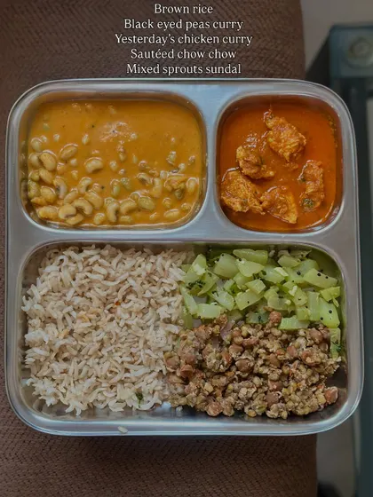 A hearty meal of brown rice, black-eyed pea curry, leftover chicken curry, sautéed chow chow, and mixed sprouts sundal.