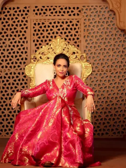 A regal, full length portrait. The actress looks like modern royalty seated on the throne, and her glowing makeup adds to the luxurious and festive feel of the image.