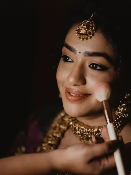 A behind-the-scenes shot of me applying blush to Anushya's cheeks, adding that final touch of bridal glow.