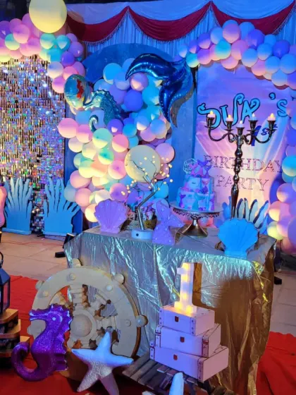 The complete mermaid party scene, with a treasure chest of props including a ship's wheel, starfish, and seahorses.