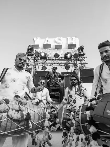 The groom's baraat arrives with a burst of energy, as dhol players lead the way, setting an electrifying and traditional tone.