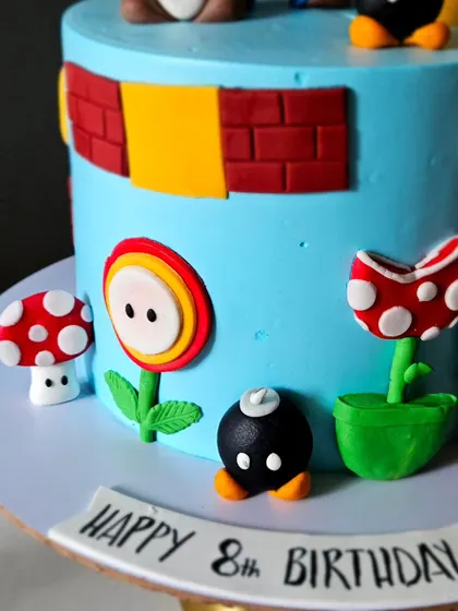 Another detail shot of the Super Mario cake, showing the texture of the brick blocks and the carefully crafted fondant flowers and bombs.