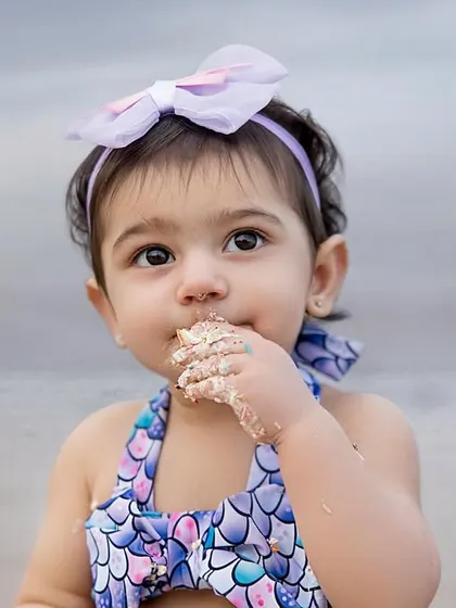 A close-up of the birthday girl enjoying a sweet taste of her cake, with the ocean waves in the background. We love these candid, detail-oriented shots.
