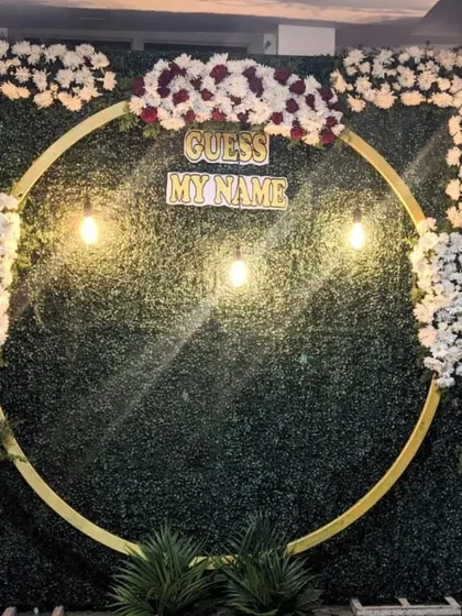 This is the same circular frame setup, showing its versatility as a backdrop for family photos during a naming ceremony celebration.