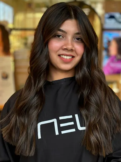 A happy client with her new sun-kissed balayage. The color complements her skin tone, and the soft waves give a relaxed, stylish finish.