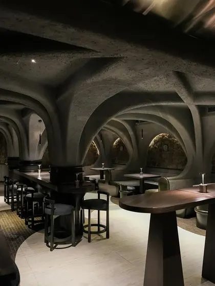 A wide shot of the main seating area at 'Call me Ten', showing how our custom furniture pieces work together to create a cohesive and immersive, cave-like dining environment.