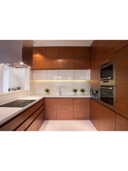 A U-shaped modular kitchen with rich, wooden cabinetry and built-in appliances. The design maximizes counter space and storage, making it highly efficient for everyday cooking.