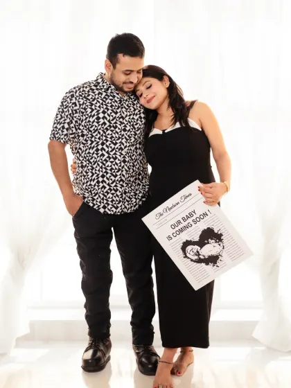 A modern and stylish announcement. The couple holds a newspaper prop, sharing their news in a creative and fun way.