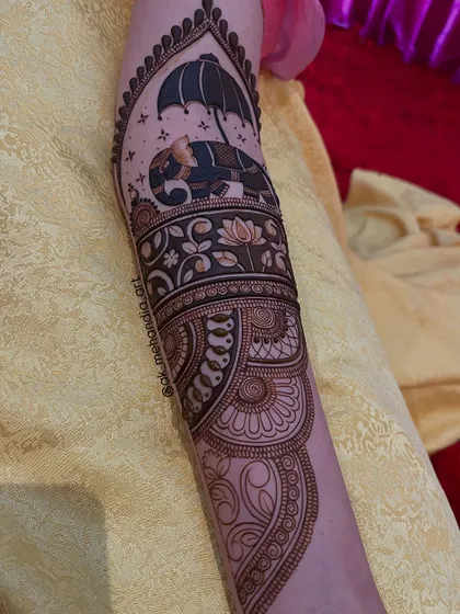 A unique arm design featuring an elephant under an umbrella, framed within an arch.