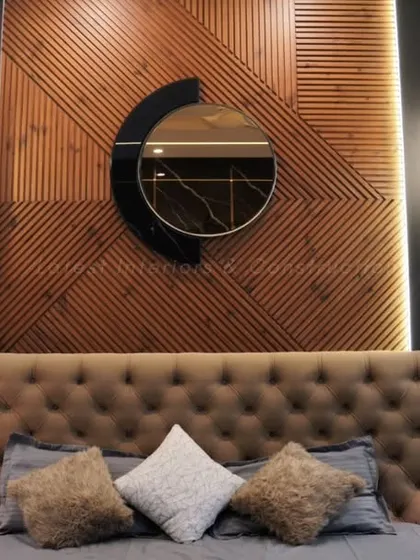 A close-up of the statement headboard, featuring a tufted suede finish and a unique wooden panel with a circular mirror. This detail adds a bespoke, artistic touch to the room.