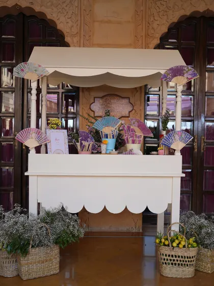 A fan station at the sunlit Mehendi lunch at Suryagarh, providing guests with beautiful and practical favors to stay cool.