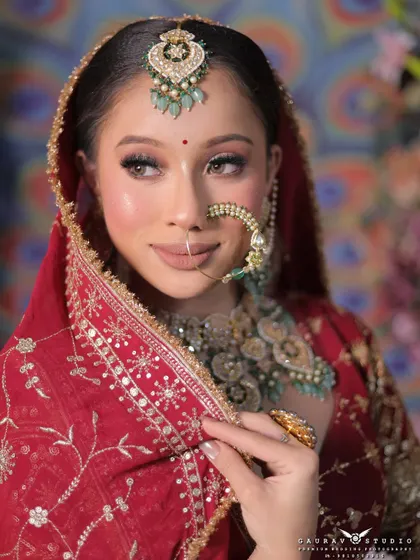 A perfect bridal portrait is all about the details. This close-up shot highlights the flawless makeup, the intricate design of the nath, and the elegant maang tikka, showing our keen eye for capturing every element of the bridal look.