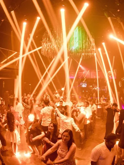 The view of a packed dance floor at Sinq Nightclub in Goa. The laser lights cutting through the haze and a crowd that's fully committed to the dance.