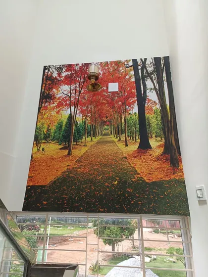An autumn forest path mural installed on a double-height staircase wall. I use scaffolding to safely and perfectly install wallpaper in high and hard-to-reach areas.