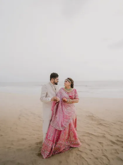 A quiet moment between the couple on the beach in Goa. The overcast sky creates a soft, romantic light perfect for capturing gentle interactions and loving gazes.